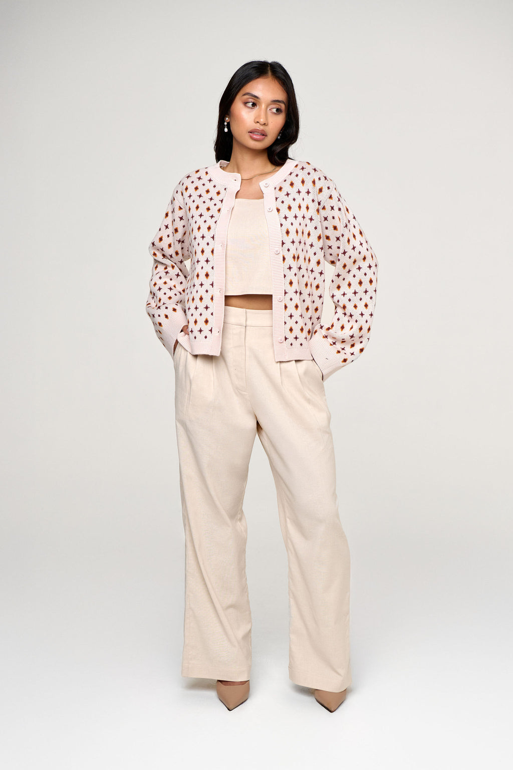 Woman wearing peite wide leg woolen pants with matching top and a jacquard knit cardigan