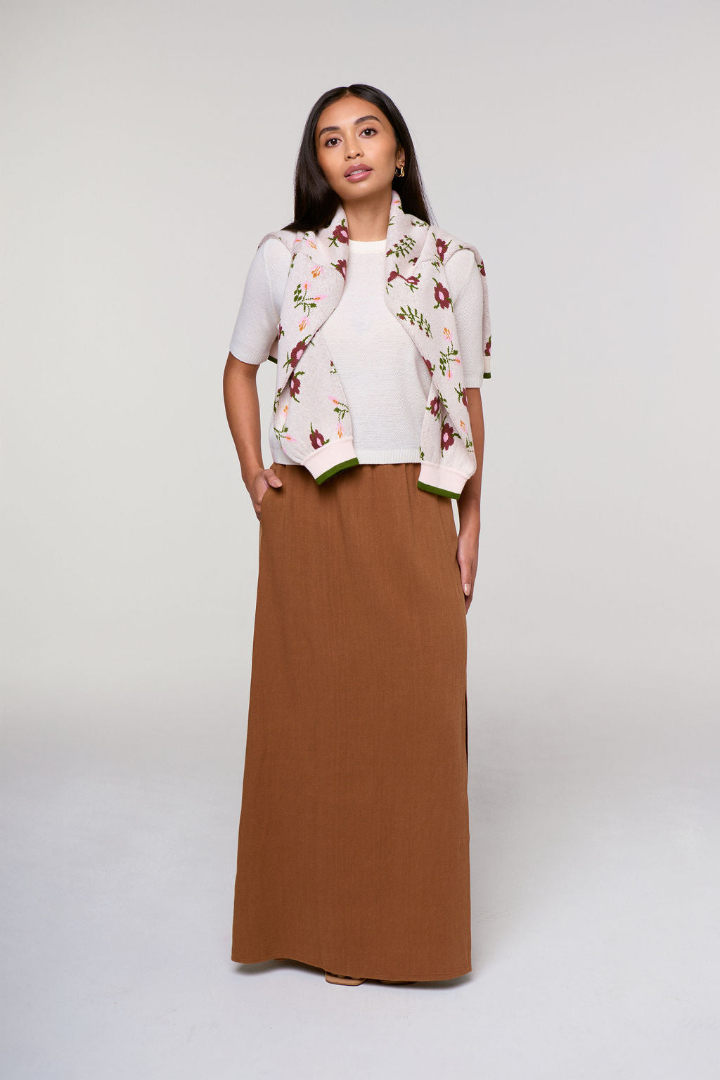 Woman wearing a floral sweater, white top, and brown maxi skirt all made for woman under 5"4 with fit and proportino at the forefront.