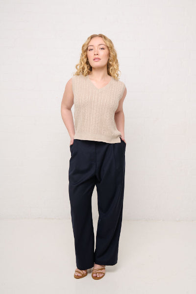 Woman wearing a petite cable knit vest and petite wool pants in navy made for shorter women