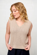 Woman wearing a beige sleeveless cable knit with a blend of silk and cotton. The vest is designed with the right size, shape, length and sleeveholes for the petite woman.