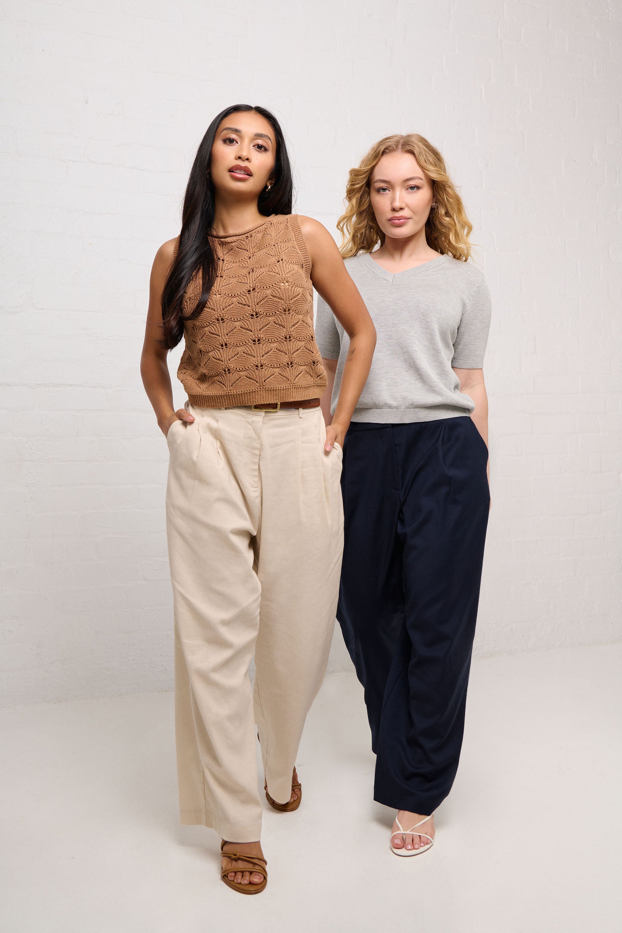 Two women standing side by side wearing premium wardrobe essentials designed for petite women on a plain background